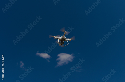 Fototapeta Naklejka Na Ścianę i Meble -  Quadcopter in a blue and clear sky on its way to 