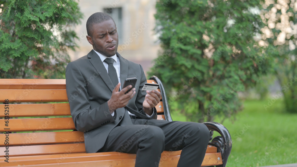 Obraz premium African Businessman Upset by Online Payment Failure on Phone Outdoor