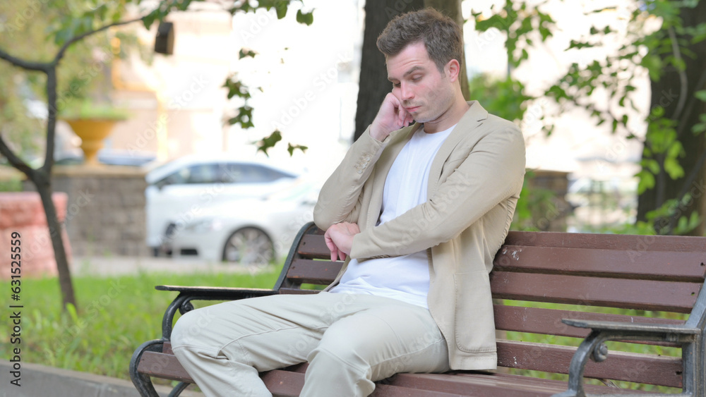 Fototapeta premium Sleeping Casual Young Man Sitting Outdoor on Bench