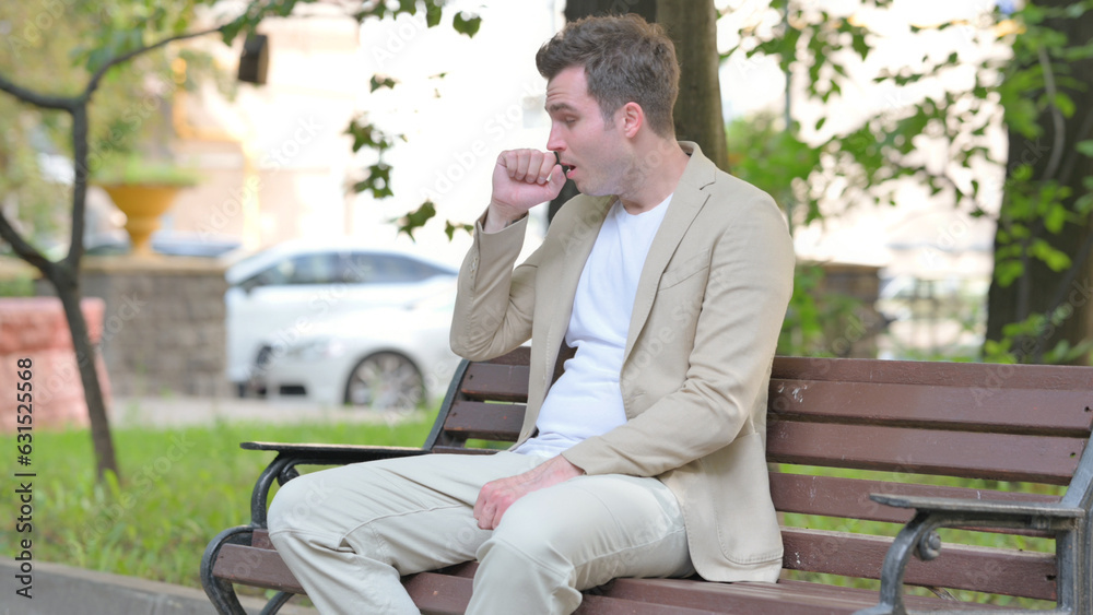 Fototapeta premium Coughing Casual Young Man Sitting Outdoor