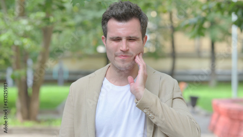 Outdoor Portrait of Casual Young Man with Toothache