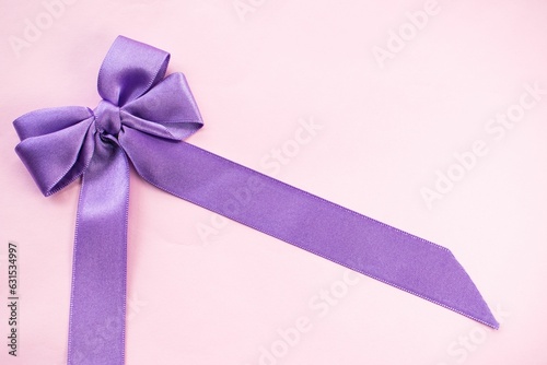 a purple ribbon and bow tied in half and placed on a table