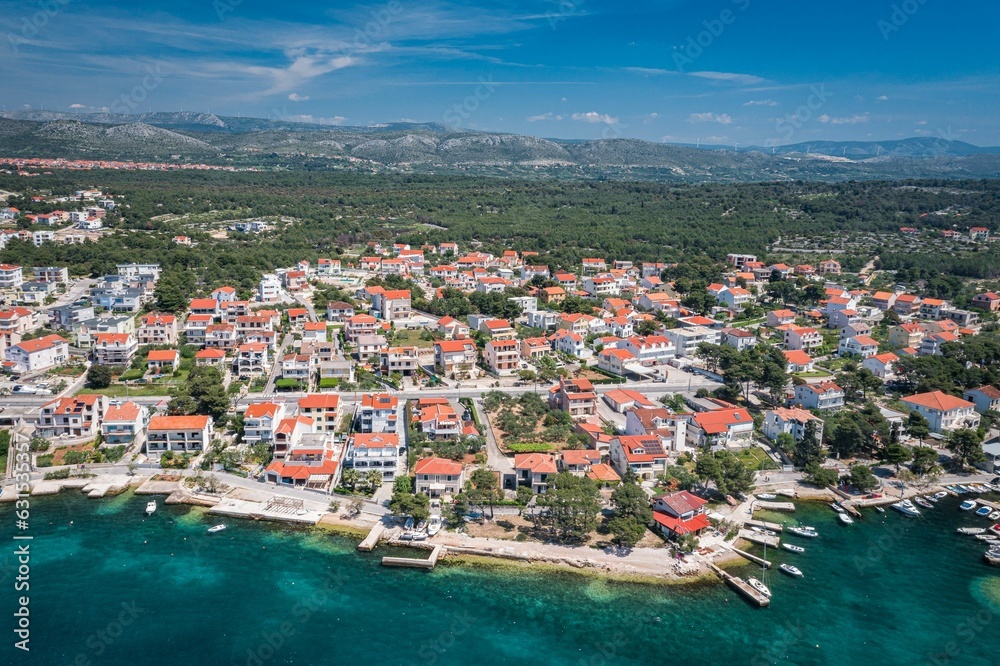 Aerial view of an idyllic coastal scene featuring a tranquil blue ocean and bright white buildings