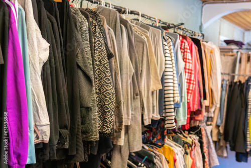 Sweden, Malmo – July 8, 2023: Different clothes on hangers, hanging clothes in second hand store