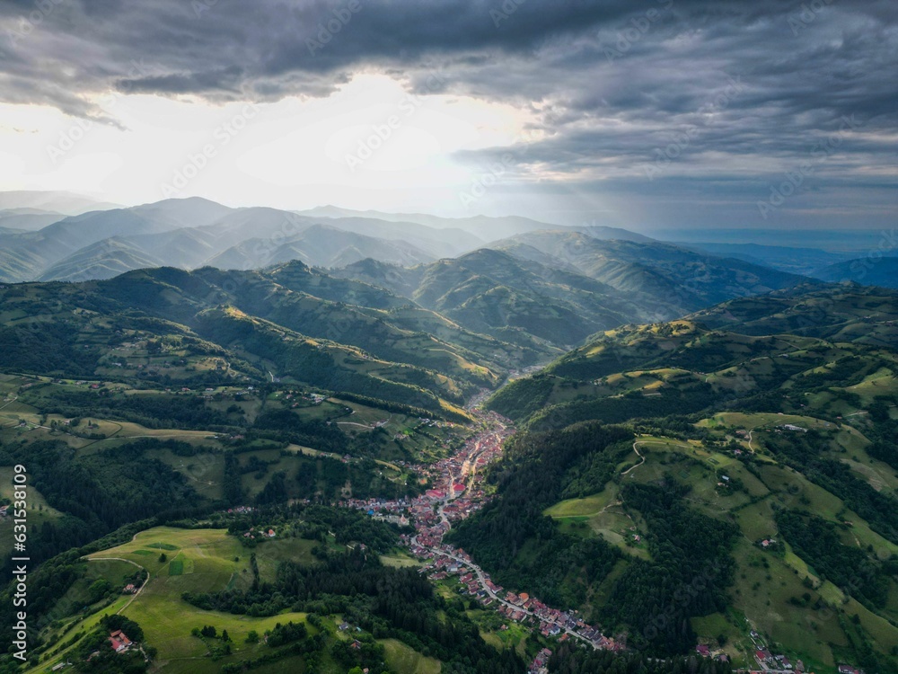 Fototapeta premium Aerial view of Poiana Marului, a picturesque village in Transylvania surrounded by lush green hills