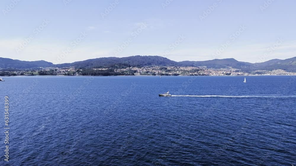 Aerial of a boat sailing in the sea with birds flying in the sky and mountains in the background Aerial of a boat sailing in the sea with birds flying in the sky and mountains in the background