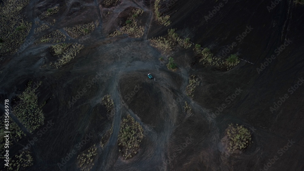Aerial view of tourists who are traveling through the volcano in a retro jeep. Indonesia, Bali, Batur volcano, a group of tourists is photographed in an off-road car on the background of the volcano.