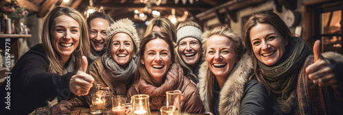 Frauen in geselliger Runde in einer Hütte im Winter mit Daumen hoch. Banner Panorama Format.