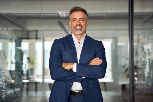 Bild auf Leinwand Handsome hispanic senior business man with crossed arms smiling at camera