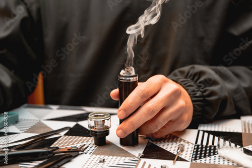 A man testing the smoke output of a vape in the vape store.