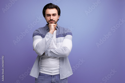 pensive brunette guy in a model appearance dreams on a studio background