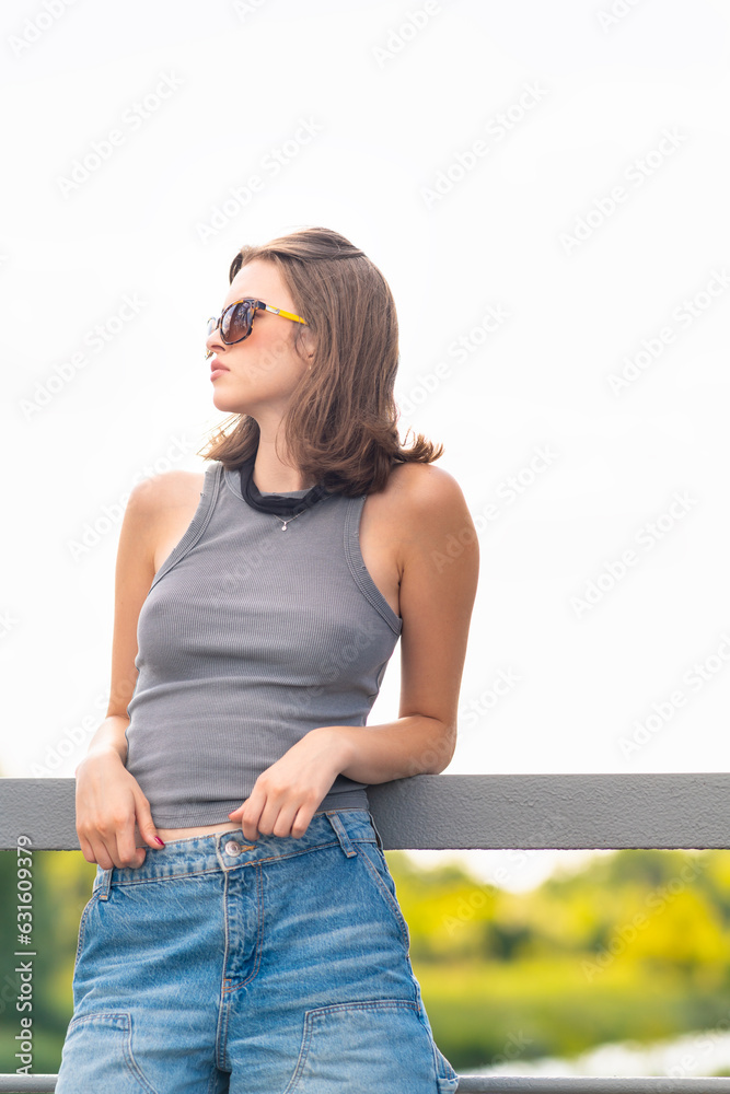 Portrait of a young woman standing on a bridge