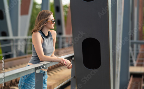 Obraz na płótnie The girl stands on the railway bridge w salonie