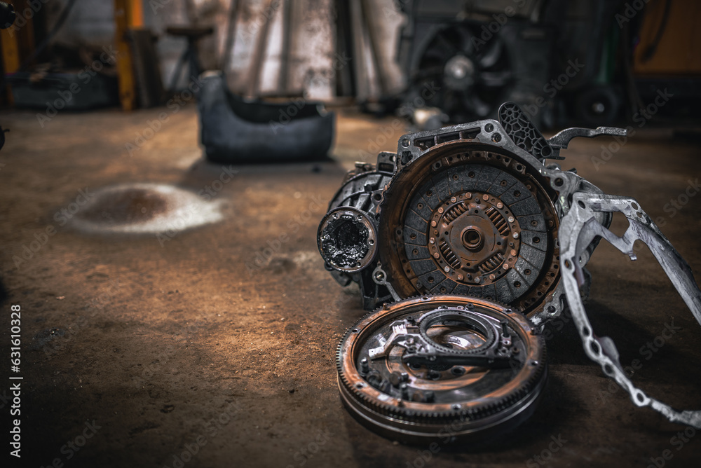 Gearbox, clutch and flywheel on the floor in the garage indergoing repar. Gearbox, clutch and flywheel on the floor in the garage indergoing repar.