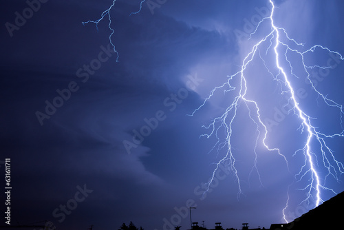 Powerful lightning strike above city roofs