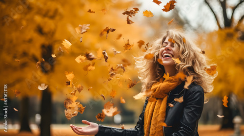 Une femme en train de jeter des feuilles en automne. photo