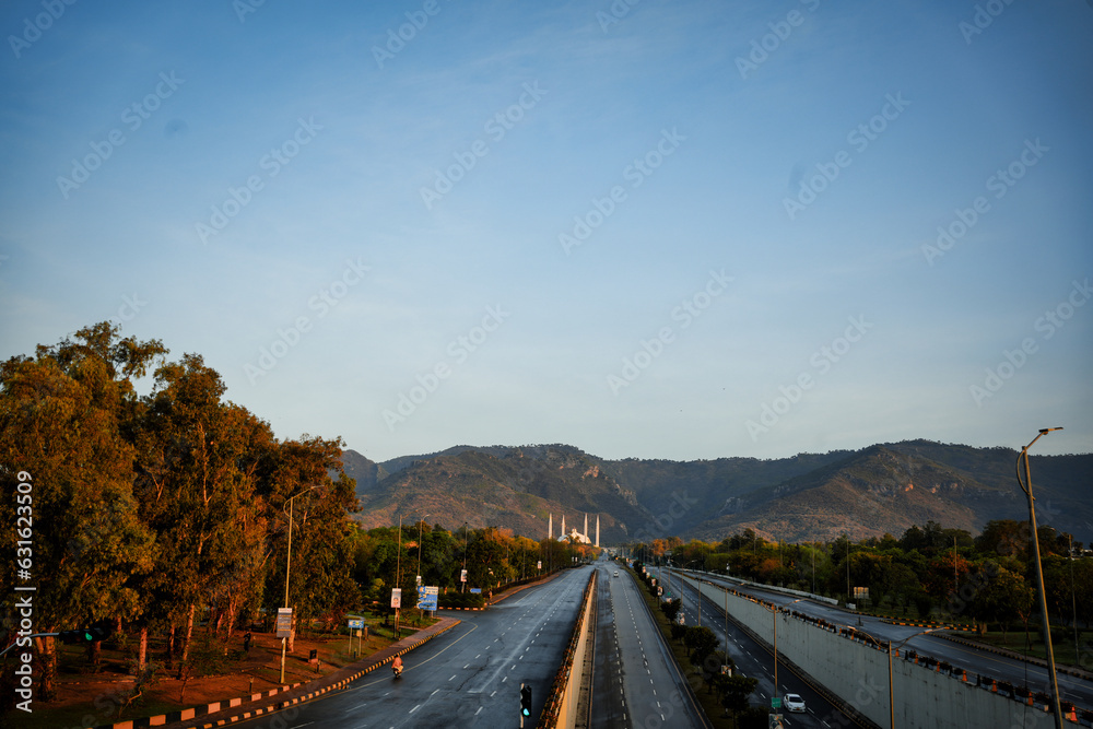 Faisal Masjid in winters, with the Margalla Hills in the background. Clear sky and green trees enhance the serene scene. Faisal Masjid in winters, with the Margalla Hills in the background. Clear sky and green trees enhance the serene scene.