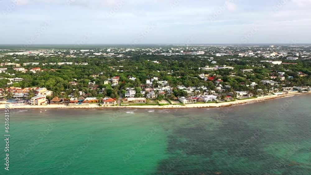 Drone view of Caribbean white sand beach and constructions surrounded by tropical green forest with cloudy sky during golden hour Drone view of Caribbean white sand beach and constructions surrounded by tropical green forest with cloudy sky during golden hour