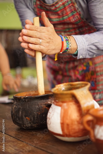 Tourist making hot chocolate with a traditional molinillo wooden whisk in Guatemala