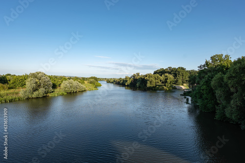 Panorama rzeki Odry w tle lekko pochmurna pogoda  b    kit nieba ziele   przy brzegu  pora letnia  Odra w odcinku wojew  dztwa Opolskiego