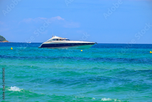 Crystal clear blue water and boats on legendary Pampelonne beach near Saint-Tropez, summer vacation on white sandy beach of French Riviera, France