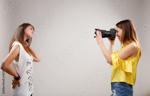 Young woman photographs younger model, both enjoy