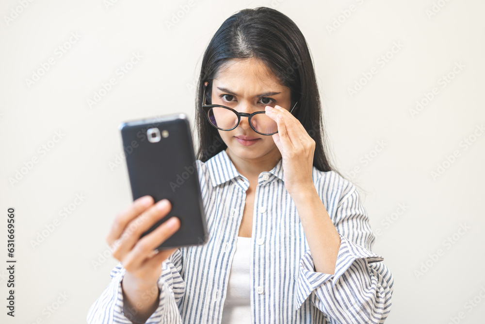 Presbyopia, Hyperopia middle aged asian woman holding eyeglasses problem with vision blurred ,trying to read text message from smart mobile phone screen, eye disease of old, eyesight farsightedness.