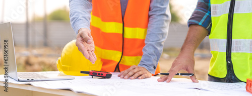 Builder team, hand of two asian young engineer, architect man, male discussing construction, follow project to build industrial plan on table at site outdoor. Engineering worker, teamwork people.