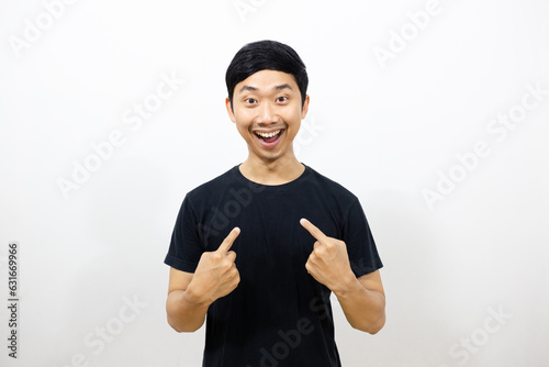 Positive asian man black shirt smile and gesture point finger at himself isolated