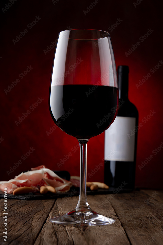 Promotional shot of glass, bottle of red wine with empty label and ...