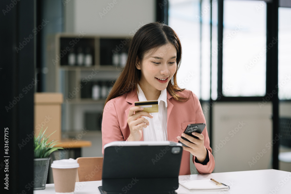 Business women use credit card to shopping online in internet website shop with computer laptop on work table in office. Business women use credit card to shopping online in internet website shop with computer laptop on work table in office.