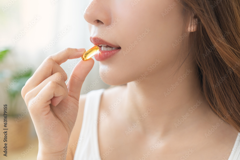Dietary supplement, pretty asian young woman, girl hand holding medical pill capsule, take or eat vitamin fish oil for treatment for skin, hair and nail strengthener near window at home, healthcare. Dietary supplement, pretty asian young woman, girl hand holding medical pill capsule, take or eat vitamin fish oil for treatment for skin, hair and nail strengthener near window at home, healthcare.