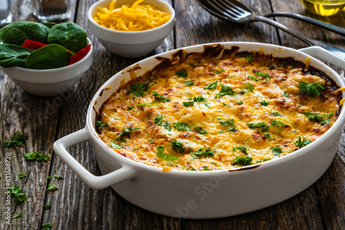 Potato casserole with mozzarella cheese and bechamel sauce on wooden table
