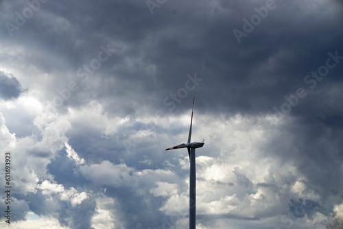 Windmühle vor dramatischem grau-weißen Wolkengebilde am Himmel bei Regen und Sturm am Nachmittag im Herbst