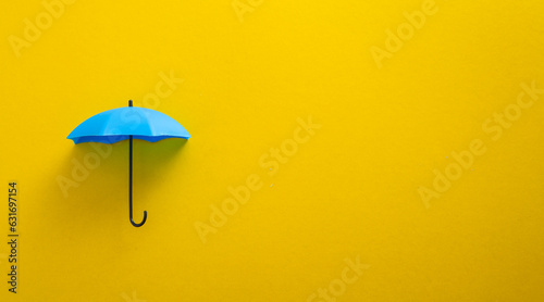 фотографія Blue toy umbrella on yellow background.