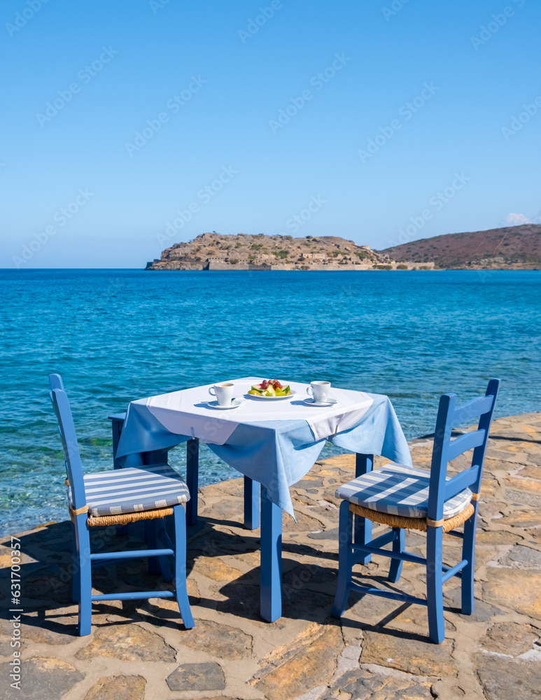 Crete Greece Plaka Lassithi, a traditional blue table and chairs on the beach in Crete Greece. Paralia Plakas, Plaka village Crete. 