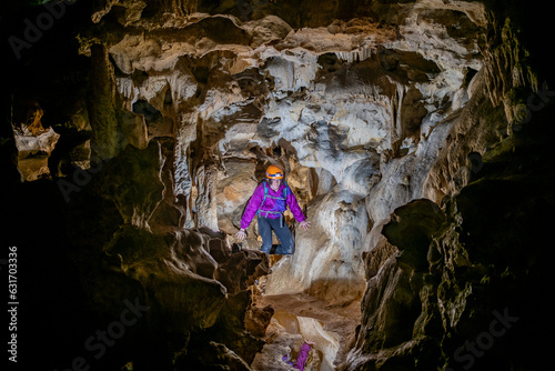 Young woman spelunking inside a cave. Feminism concept. Concept of women's sport.