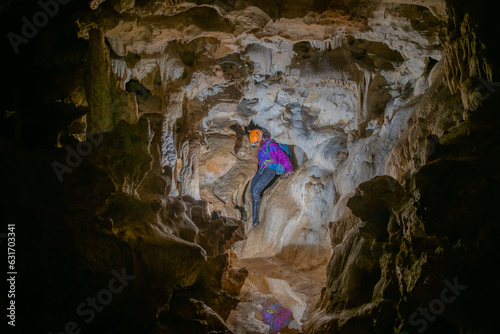 Young woman spelunking inside a cave. Feminism concept. Concept of women's sport. photo