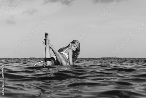 Surfer woman on a wave. Happy woman lying on surfboard