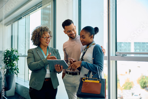 Slika na platnu Young multiracial couple and their financial advisor using touchpad during meeting