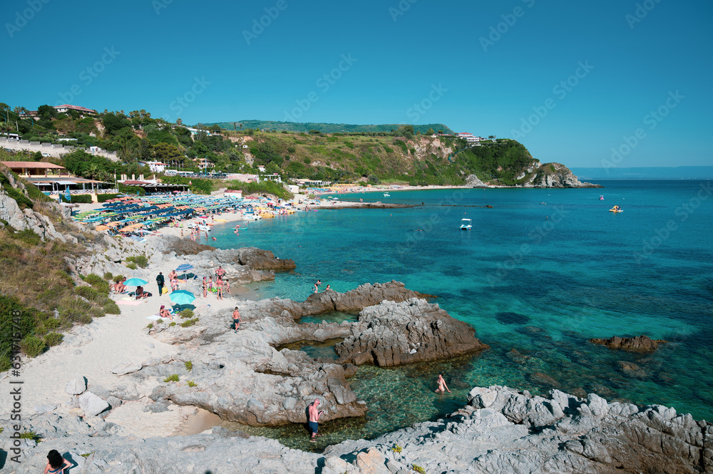 Michelino beach in Calabria, near Tropea, with its crystal clear Caribbean sea. Swimmers relax by sunbathing and taking refreshing baths