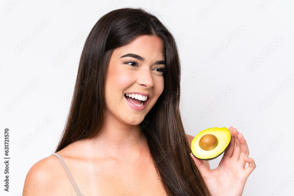 Young Brazilian woman isolated on white background holding an avocado while smiling. Close up portrait Young Brazilian woman isolated on white background holding an avocado while smiling. Close up portrait