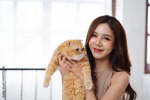 Happy Asian woman owner cute cat playful in a home. Friendship of pet and human people lifestyle.
