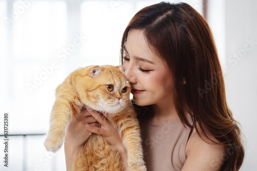 Happy Asian woman owner cute cat playful in a home. Friendship of pet and human people lifestyle.