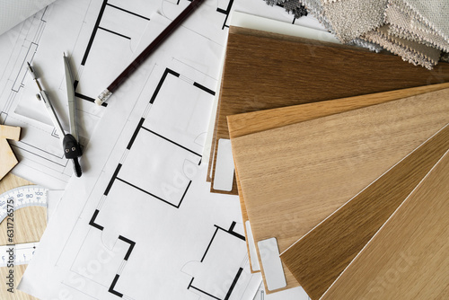Wooden flooring samples, home floor plans, building structural blueprint projects, accessories for architect, interior designer. Flat lay design composition. Choosing different wood shades, textures.