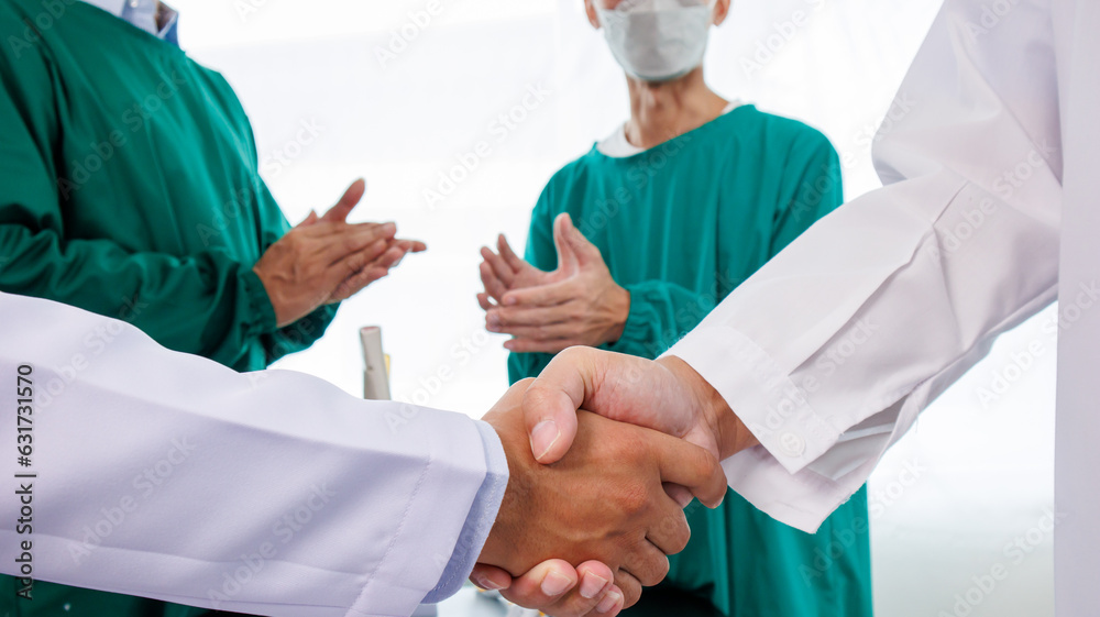 Multiracial medical team having a meeting with doctors in white lab coats and surgical scrubs seated at a table discussing a patients records Multiracial medical team having a meeting with doctors in white lab coats and surgical scrubs seated at a table discussing a patients records