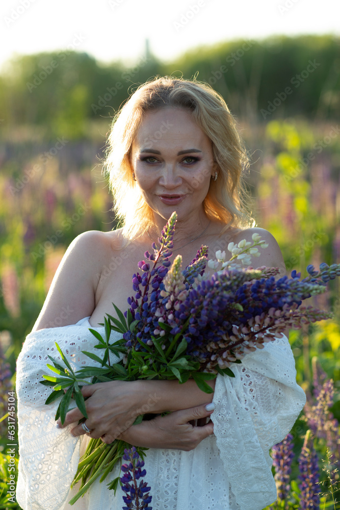 beautiful blond woman in white dress on lupin field summer background close up dawn portrait. High quality photo beautiful blond woman in white dress on lupin field summer background close up dawn portrait. High quality photo