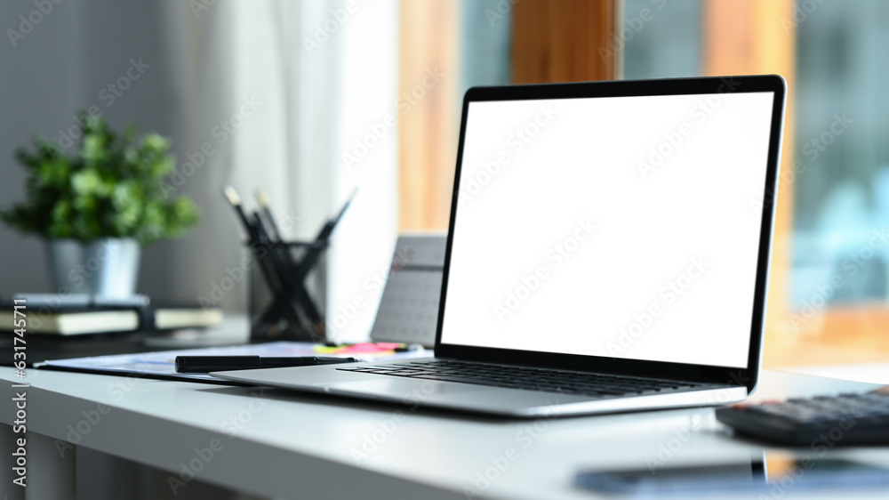 Home office interior , laptop computer with blank screen and office supplies on white table. Home office interior , laptop computer with blank screen and office supplies on white table.