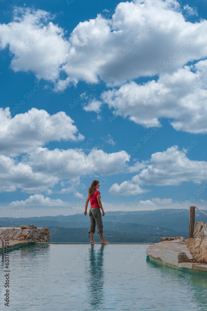 Woman stands on the edge of the swimming pool