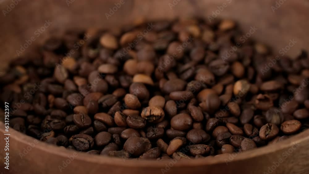 Coffee beans falling in wooden bowl. close up Coffee beans falling in wooden bowl. close up